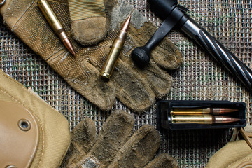 Carbine clip, ammo, gloves  and shutter lies on  a background.