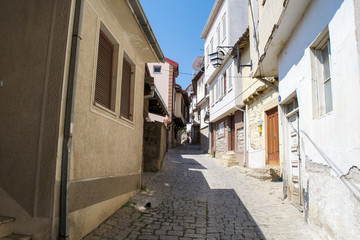 Fototapeta na wymiar An empty street heading up hill in the faded old town of Ohrid, Macedonia