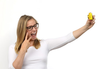 Hübsche blonde Frau mit Brille zwinkert und macht ein Foto von sich