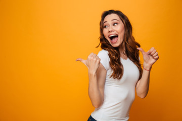 Happy brunette woman in t-shirt looking and pointing away