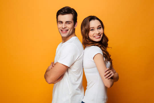 Portrait of a happy young couple standing with arms folded