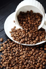 Roasted coffee beans in white mug on table 