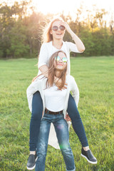 Pretty young women carries on the back another young women