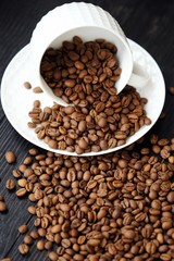 Roasted coffee beans in white mug on table  