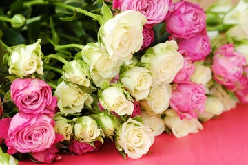 Beautiful bouquet of white and pink roses on pink background  