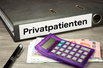 Taschenrechner, Euro Geldscheine und ein Ordner mit dem Aufdruck Privatpatienten