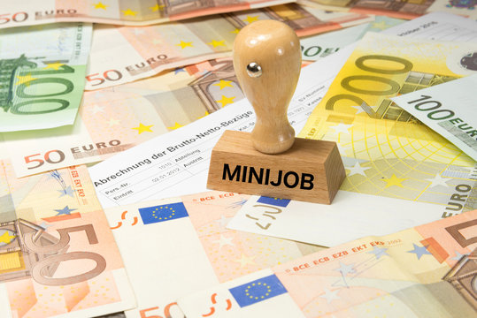 Eine Lohnabrechnung, Euro Geldscheine und ein Stempel mit dem Aufdruck Minijob