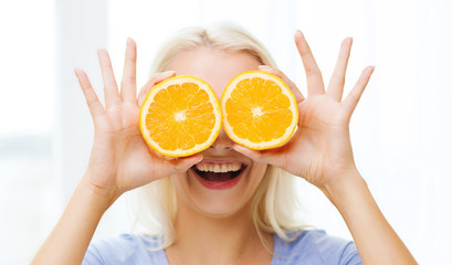 happy woman having fun covering eyes with orange