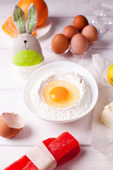 set of ingredients for easter baking and easter bunny on a white background