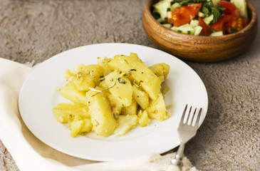 Fresh baked potato with vegetable salad on grey background
