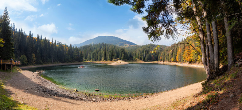 Fototapeta Lake in the mountains surroundes by pine trees