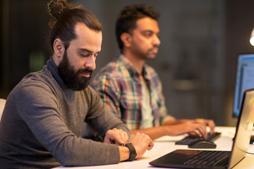 creative man with smartwatch working at office