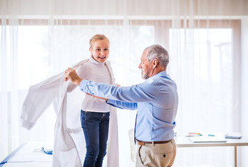 Fototapeta premium Senior doctor and a small girl in his office.