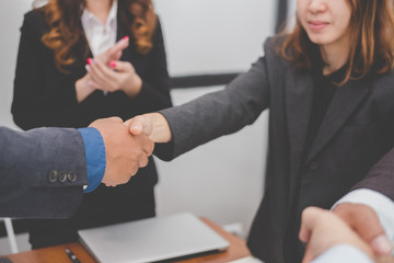 Business people shaking hands after finishing up meeting. co worker colleagues handshaking after conference. teamwork, partnership, collaboration, corporate concept.