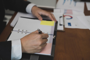 businessman writing on paper at workplace. young male entrepreneur man handwriting note at office. paperwork on table.