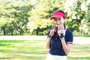 Young Asian woman playing golf and smiling in winning action. Sport background with copy space.