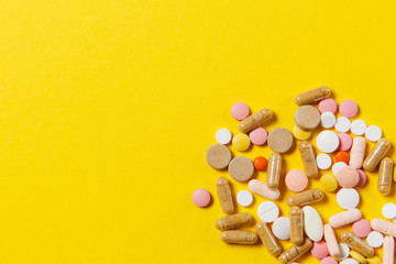 Medication white colorful round tablets arranged abstract on yellow color background. Aspirin, capsule pills for design. Health, treatment, choice healthy lifestyle concept. Copy space advertisement.