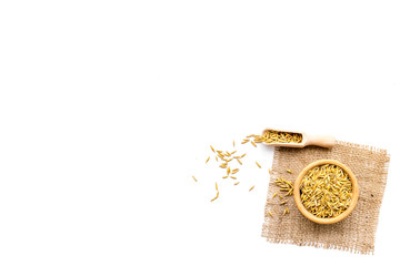 Raw oats in bowl and scoop on white background top view copy space