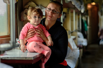 A young mother travels in glasses along with a wonderfully beautiful daughter