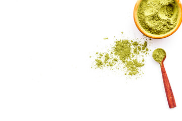 Powdered matcha green tea in bowl and scattered on white background top view copy space