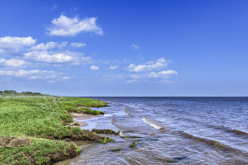 Fototapeta na wymiar Lake shore with blue sky
