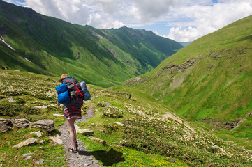 Fototapeta na wymiar Girl with a big backpack is traveling in the Caucasus mountains, Georgia.