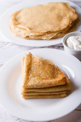pancakes with sour cream on a white plate