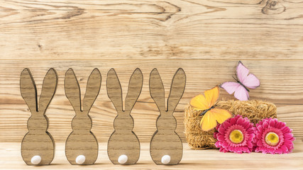 Vier Osterhasen mit Blumen und Schmetterlinge