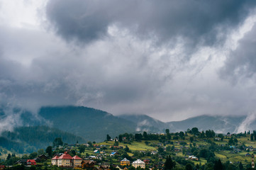 Beautiful nature landscape. Scenic view at misty foggy mountains peaks covered with rainy stormy...