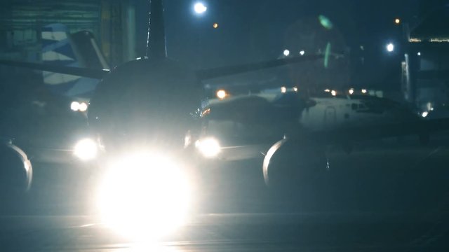 Airplane maneuvers on a runway at night before take off