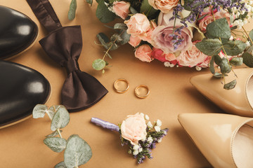 Top view of bride and groom shoes, two gold rings