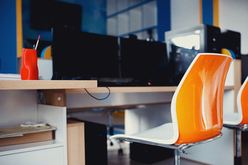 Workplace. Modern Chair in orange stands computer table