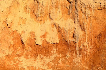 Detail of natural orange brown loamy (clay) soil of ravine wall with rough texture background
