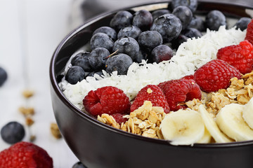 Healthy Breakfast Buddha Bowl with berries, coconut, bananas and granola.