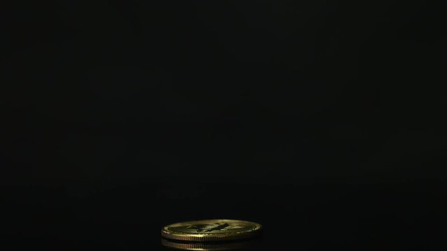 One golden Bitcoin on a black background.