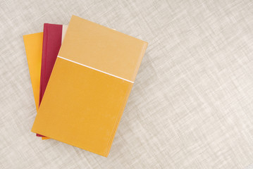 a bunch of books is on the table, yellow book,  empty space, texturing backgrounds, three books