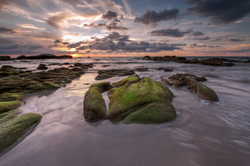 colorful sunset sky with rocks covered by green moss at Kudat Sabah Malaysia.