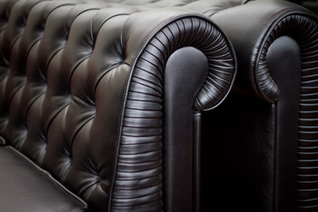 Obraz premium vintage style of interior decoration the black leather sofa.
