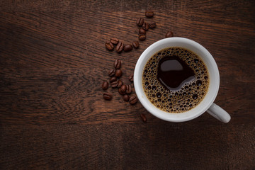 A cup of coffee on a wooden table.