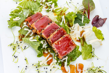 Tuna fillet with sesame over white background.