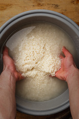 the cook is washing the rice for sushi.