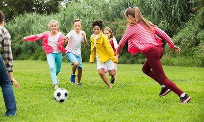 Obraz na płótnie Canvas Kids playing football in park