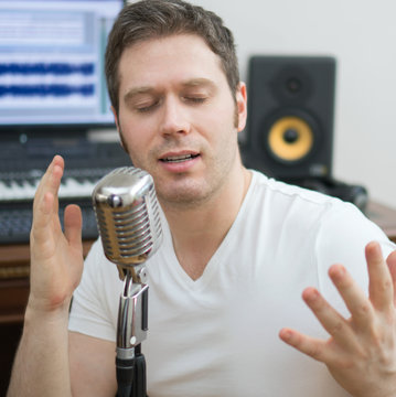 Handsome man rehearsing a song in the music studio.