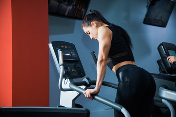 Fit woman on cardio stepper machine at gym. Female athlete doing warming workout on a treadmill....