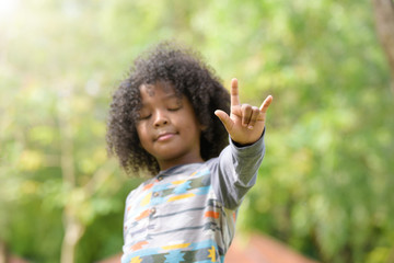 Mixed race boy show I love you sign language .