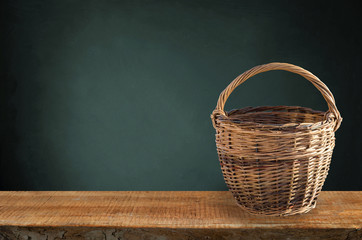 Isolated basket. One vintage wicker basket on a shelf is isolated on a black background