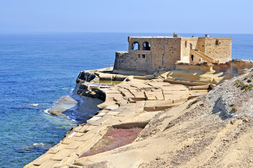 Island of Gozo with an old building and the sea