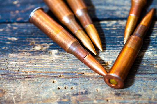 Still life with five rifle cartridges