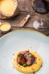 the amazing calf tongue dish with palenta in an expensive restaurant. Exclusive restaurant. Delicious food and dessert. Meat grill. Grilled meat for dinner. vertical photo