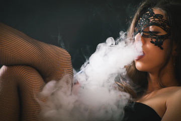 Young, beautiful girl smoke a hookah at club